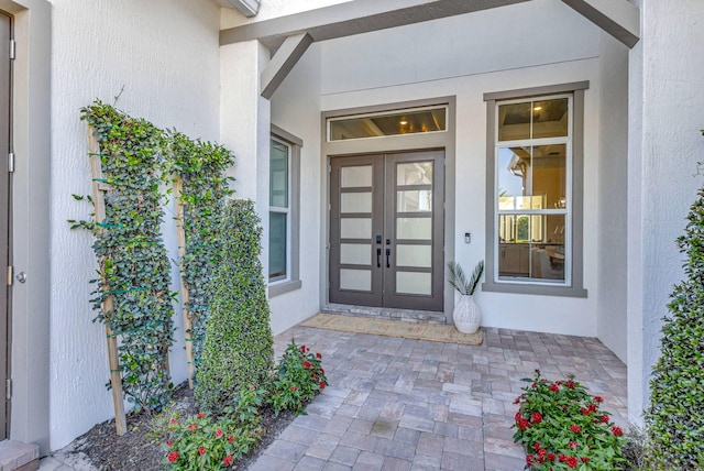 property entrance featuring french doors and stucco siding