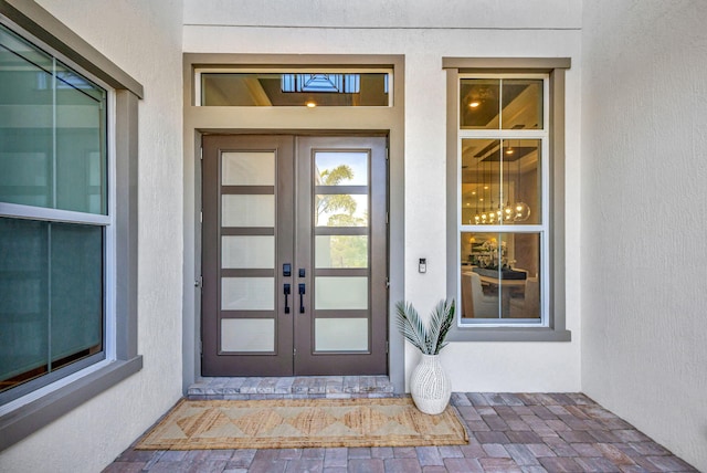 doorway to property featuring french doors and stucco siding