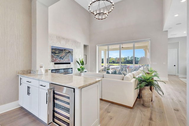 interior space with light wood-style floors, wine cooler, and light stone counters