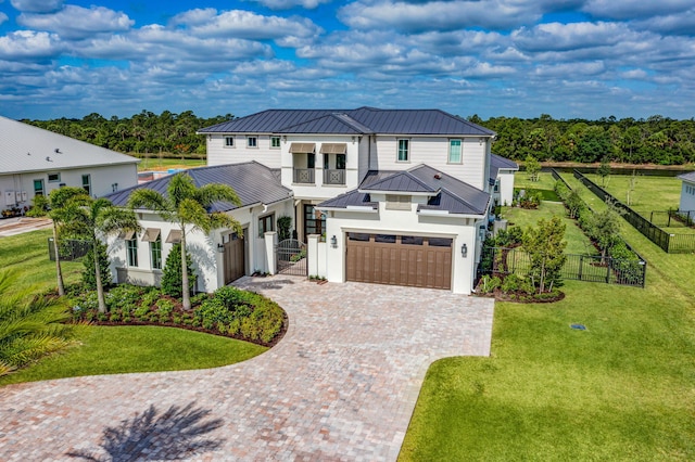 view of front of house featuring a standing seam roof, metal roof, driveway, and a front yard