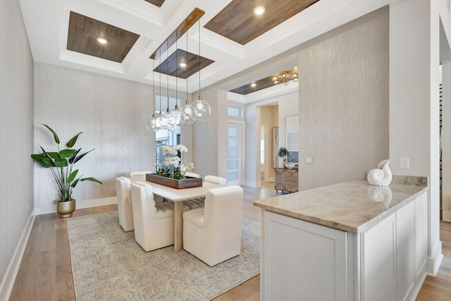 dining space with beam ceiling, light wood finished floors, a chandelier, baseboards, and coffered ceiling