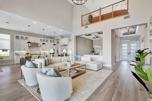 living area featuring a notable chandelier, a healthy amount of sunlight, and visible vents