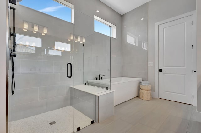 bathroom featuring a soaking tub and a stall shower
