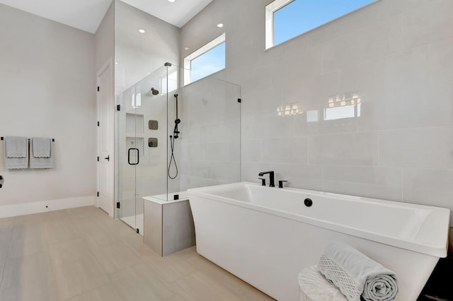 bathroom featuring a freestanding tub and a shower stall
