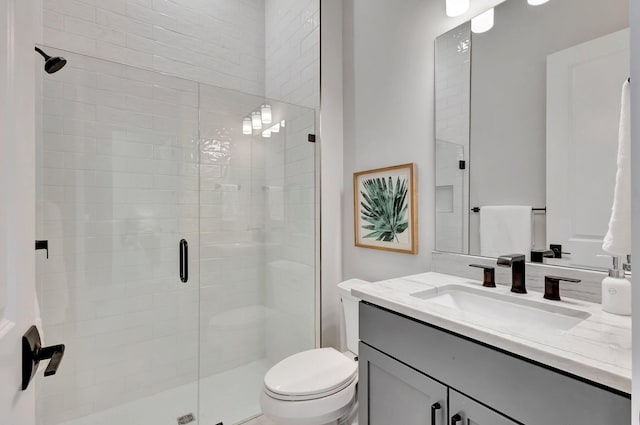 bathroom featuring vanity, toilet, and a stall shower