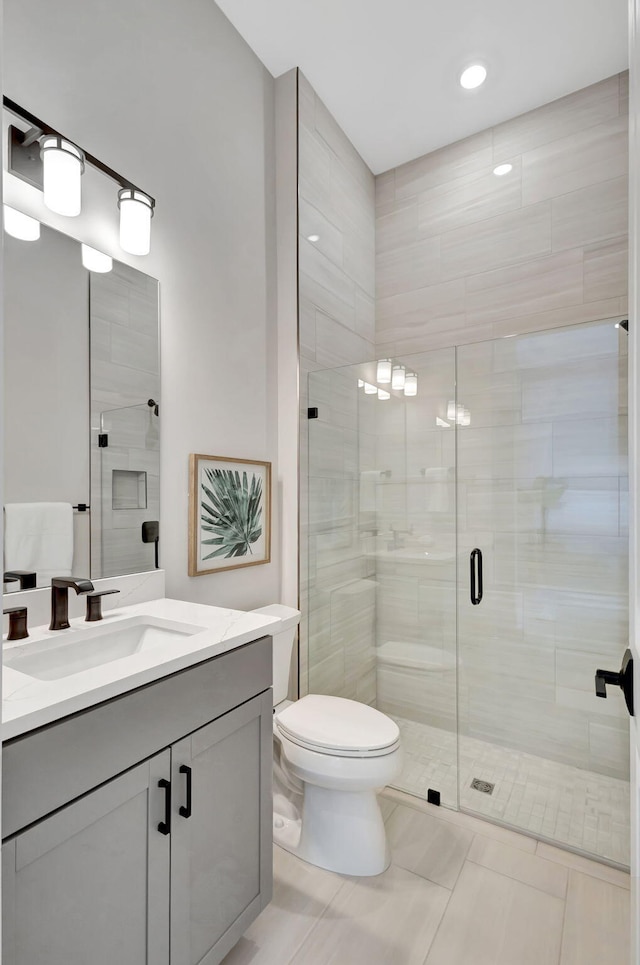 full bathroom with vanity, a stall shower, and toilet