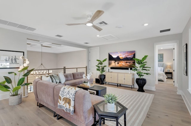 living room with visible vents, wood finished floors, and beam ceiling
