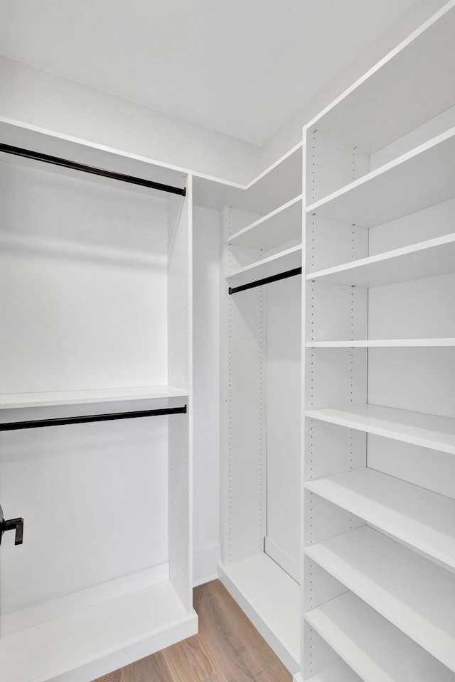 walk in closet with wood finished floors