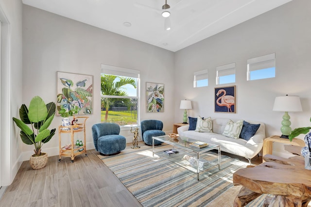 living room with baseboards, ceiling fan, and wood finished floors