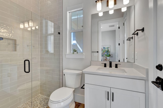 bathroom with vanity, toilet, and a stall shower