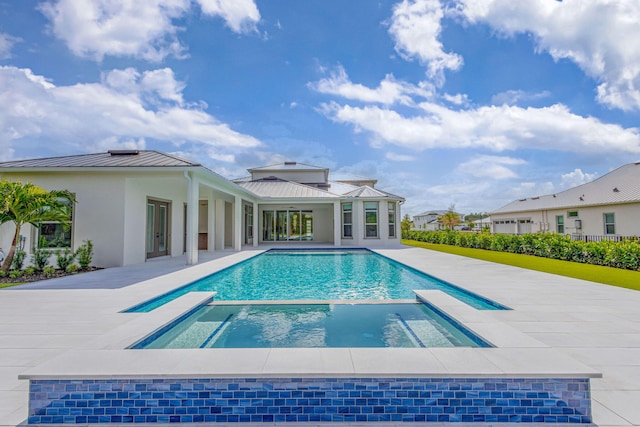 view of pool with a pool with connected hot tub and a patio area