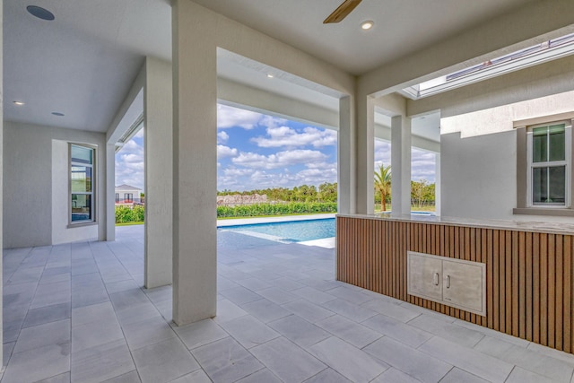 pool with a ceiling fan and a patio area