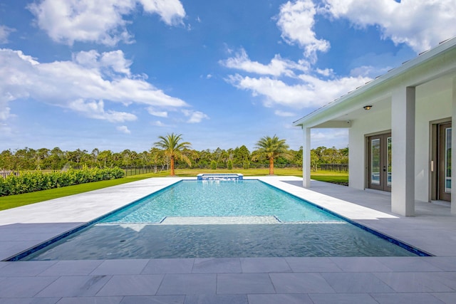 view of pool with a patio area, fence, french doors, and a pool with connected hot tub