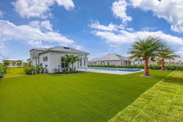 view of yard featuring a pool with connected hot tub