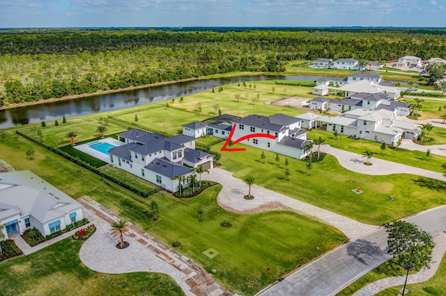 birds eye view of property featuring a residential view, a water view, and a forest view