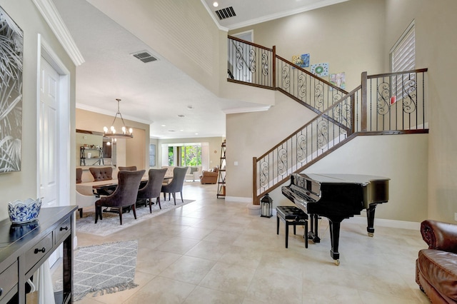 tiled entrance foyer featuring ornamental molding, stairs, a chandelier, and visible vents