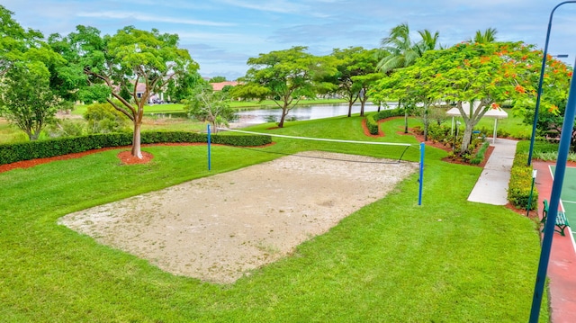 view of home's community with volleyball court, a water view, and a yard