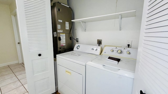 1942 SE Carvalho St, Port Saint Lucie, FL 34983 - laundry room with laundry area, washing machine and clothes dryer, light tile patterned floors, baseboards, and heating unit