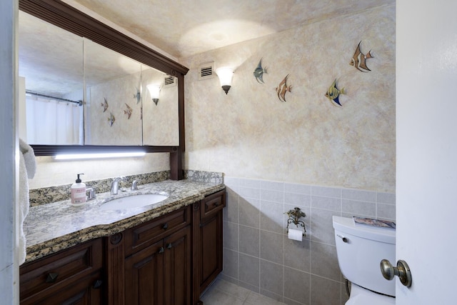 3800 Washington Rd Unit 1002, West Palm Beach, FL 33405 - full bath with toilet, vanity, tile walls, and a wainscoted wall