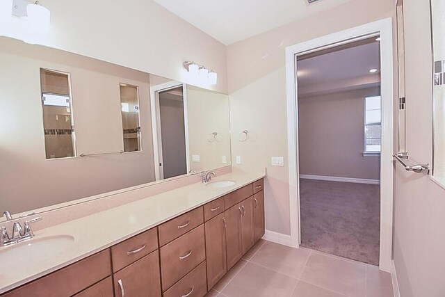 12546 Triumph Ln, Palm Beach Gardens, FL 33412 - bathroom with double vanity, baseboards, a sink, and tile patterned flooring