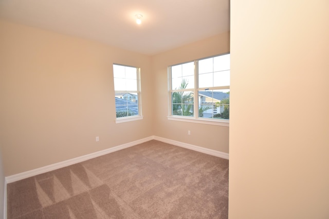 12546 Triumph Ln, Palm Beach Gardens, FL 33412 - spare room featuring a healthy amount of sunlight, carpet floors, and baseboards