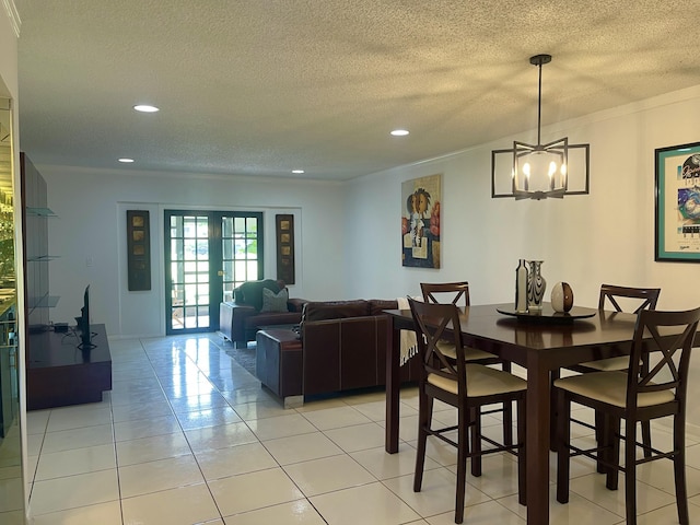 dining room featuring an inviting chandelier, a textured ceiling, recessed lighting, light tile patterned floors, and ornamental molding