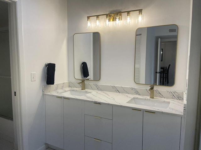 bathroom with double vanity, visible vents, and a sink