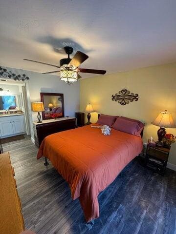 bedroom with connected bathroom, a ceiling fan, and wood finished floors