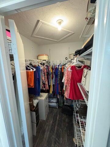 spacious closet with wood finished floors and attic access