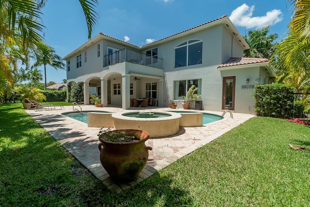 4510 Island Reef Dr, Wellington, FL 33449 - back of property with a balcony, stucco siding, a ceiling fan, a lawn, and an in ground hot tub
