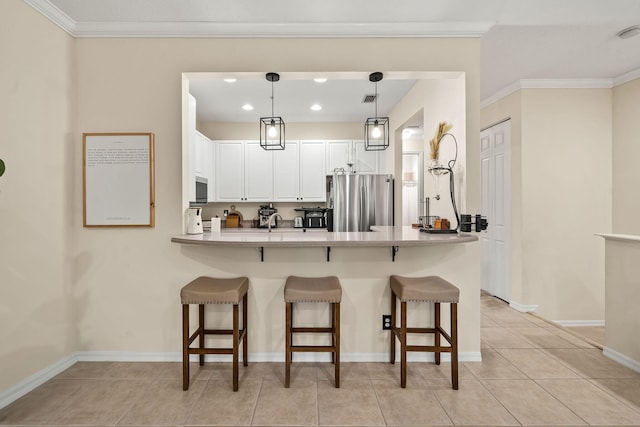 kitchen with stainless steel appliances, a peninsula, a breakfast bar area, white cabinets, and hanging light fixtures