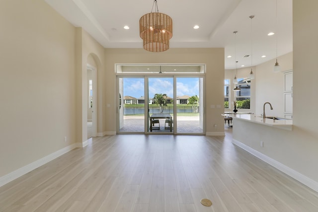 9252 SW Miracoli Way, Port Saint Lucie, FL 34987 - interior space featuring light wood finished floors, a raised ceiling, recessed lighting, and an inviting chandelier