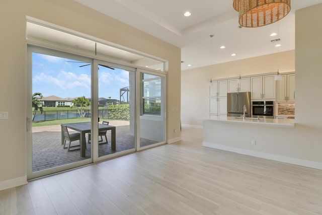 9252 SW Miracoli Way, Port Saint Lucie, FL 34987 - unfurnished living room with a wealth of natural light, light wood-style flooring, baseboards, and recessed lighting