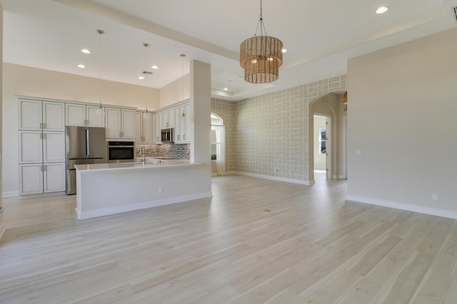 9252 SW Miracoli Way, Port Saint Lucie, FL 34987 - kitchen featuring a sink, stainless steel appliances, open floor plan, a notable chandelier, and arched walkways