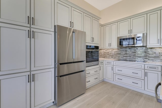 9252 SW Miracoli Way, Port Saint Lucie, FL 34987 - kitchen with stainless steel appliances, backsplash, light countertops, and light wood-type flooring