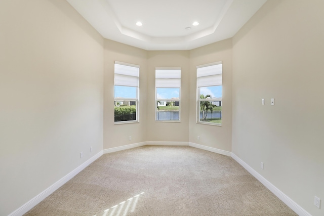 9252 SW Miracoli Way, Port Saint Lucie, FL 34987 - spare room featuring light carpet, a raised ceiling, baseboards, and recessed lighting
