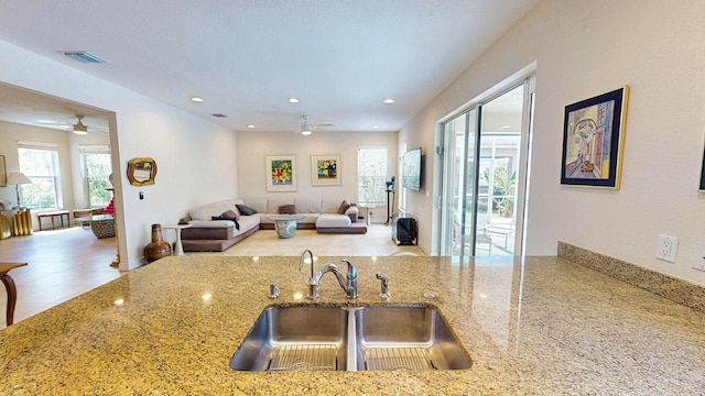2323 NW Padova St, Port Saint Lucie, FL 34986 - kitchen featuring a ceiling fan, visible vents, light stone countertops, a sink, and open floor plan