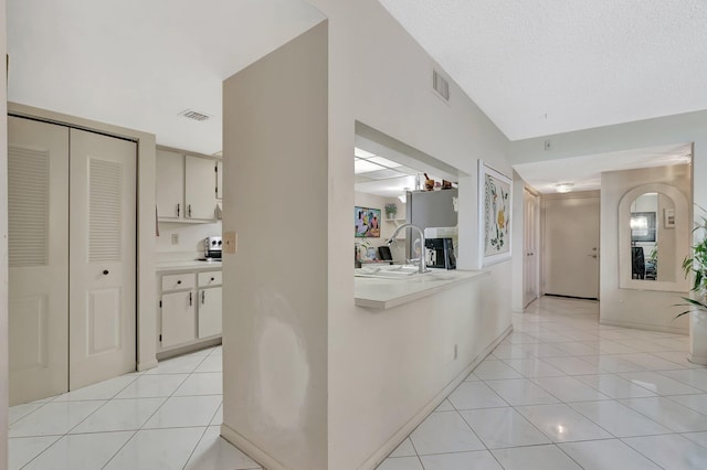 950 Egret Cir Unit 5409, Delray Beach, FL 33444 - corridor with visible vents, a sink, lofted ceiling, and light tile patterned flooring