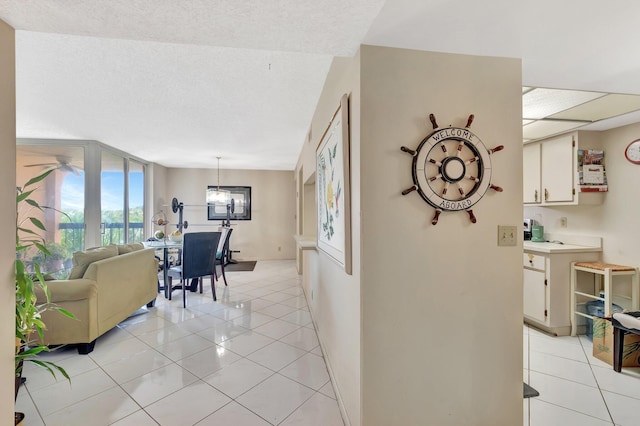 950 Egret Cir Unit 5409, Delray Beach, FL 33444 - hall featuring baseboards, a textured ceiling, an inviting chandelier, and light tile patterned floors
