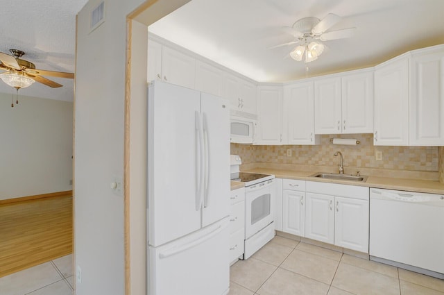 kitchen featuring white appliances, a sink, a ceiling fan, light tile patterned flooring, and light countertops