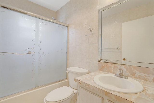 full bathroom with tile walls, vanity, toilet, enclosed tub / shower combo, and tasteful backsplash