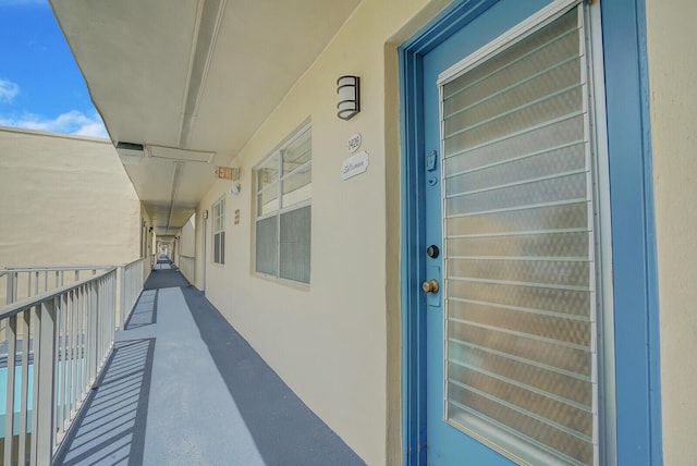 property entrance featuring a balcony and stucco siding