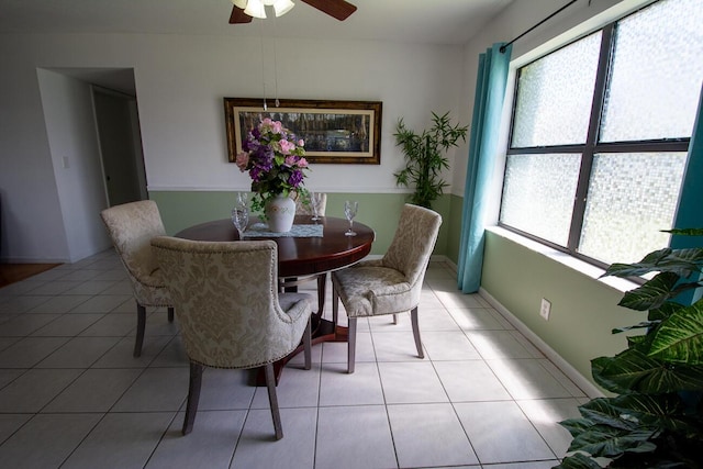 dining space featuring baseboards, a ceiling fan, light tile patterned flooring, and a wealth of natural light
