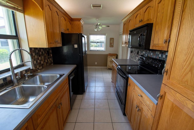 kitchen with decorative backsplash, ceiling fan, a sink, baseboards, and black appliances