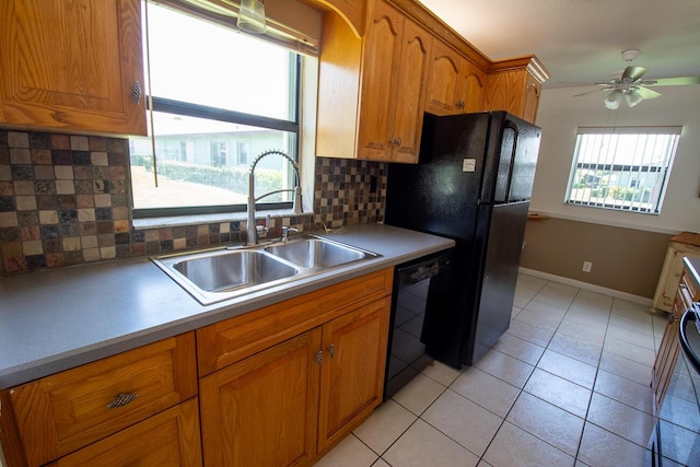 kitchen featuring brown cabinets, ceiling fan, a sink, decorative backsplash, and black appliances