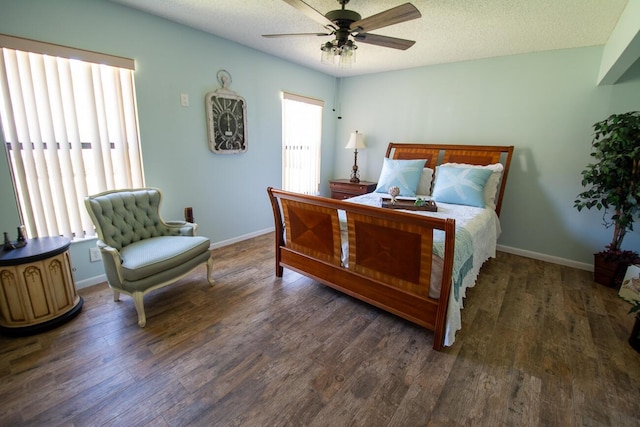 bedroom with baseboards, multiple windows, and wood finished floors