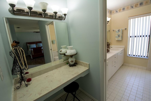 bathroom with tile patterned floors, baseboards, and vanity