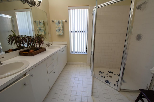 full bathroom with double vanity, a sink, a stall shower, and tile patterned floors