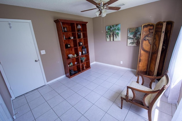 sitting room featuring light tile patterned floors, baseboards, a ceiling fan, and visible vents