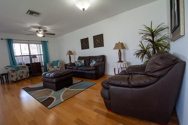 living area with ceiling fan, wood finished floors, and visible vents